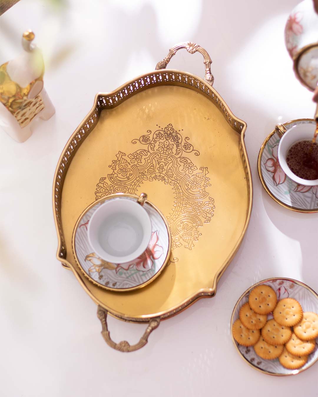 Elegant gold decorative tray with intricate lace cut-out design and handle, perfect for sophisticated table settings.