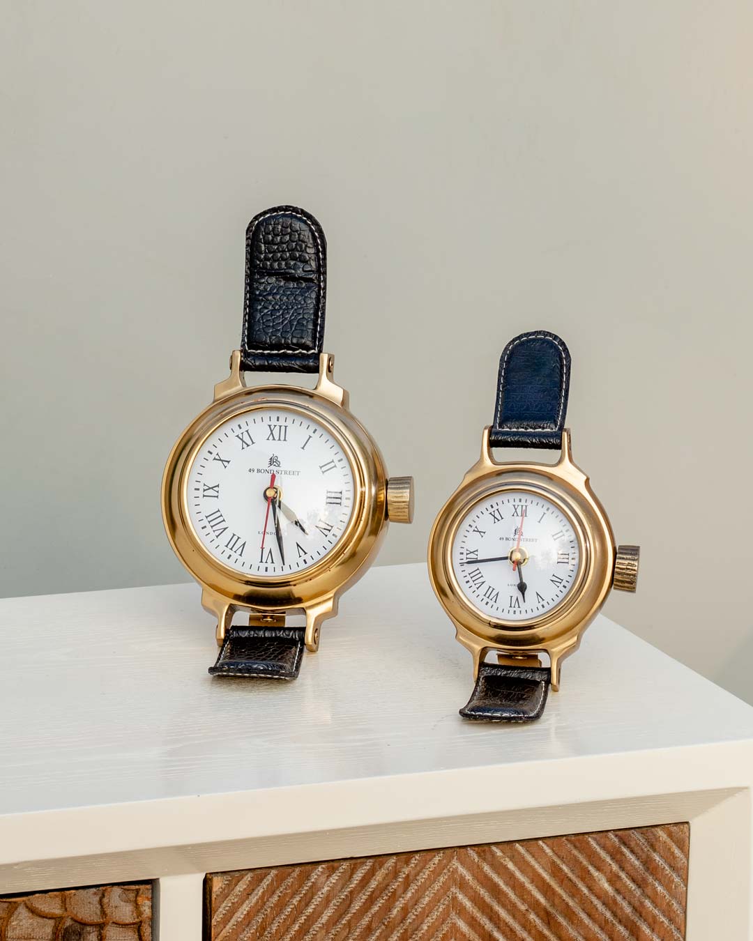 Pair of small leather strap table clocks with golden accents for sophisticated interiors.