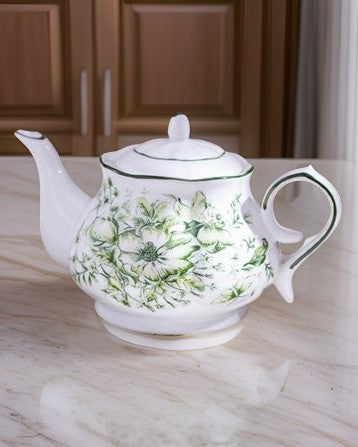 Classic emerald Devonshire Ceramic Tea Kettle with intricate floral design placed on a white kitchen table.