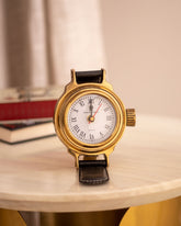 Leather-handled small table clock with a vintage gold rim for classic decor.