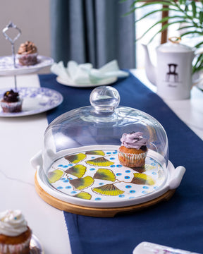 The Ginkgo Cake Stand adorned with a pattern of leaves and a glass top, creating an eye-catching centerpiece for any dessert table.